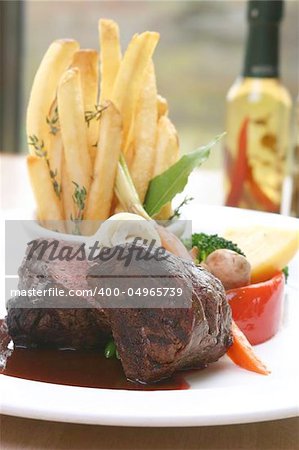 8 oz Tenderloin Steak topped with truffle butter. Served with broccoli, beans, horseradish and fries. Shallow DOF.