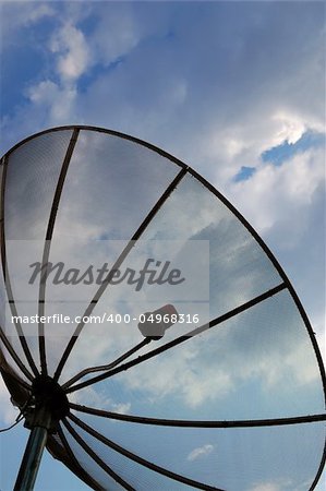 A satellite dish over a cloudy sky.