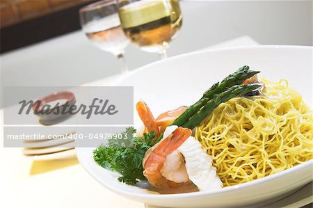 Delicious seafood fried noodles with shrimps, fish, squid and mushroom. Served with asparagus.