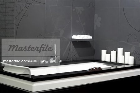 Contemporary black bathroom with geometric bathtub and candles