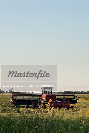 A combine in a field with copyspace available in the sky