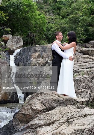 Happy bride and groom standing on top of a mountain.