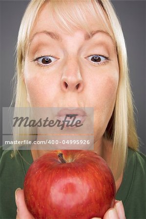 Beautiful Woman With Apple Against A Grey Background