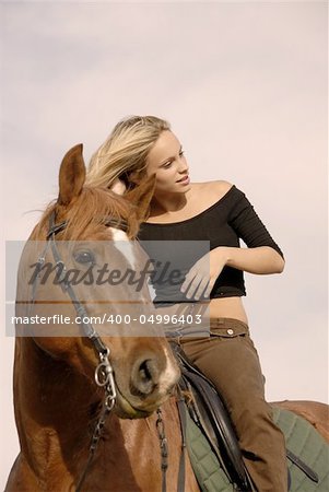 riding girl and her brown stallion. focus on the teen