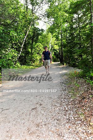 Happy middle aged man walking on a forest trail