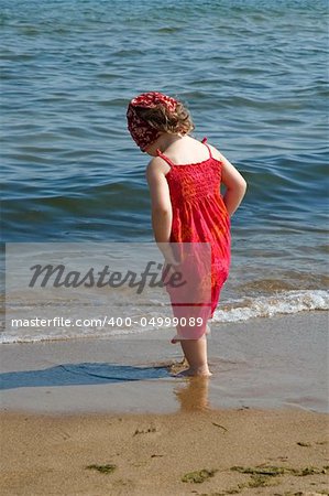 little girl in red dress on the beach