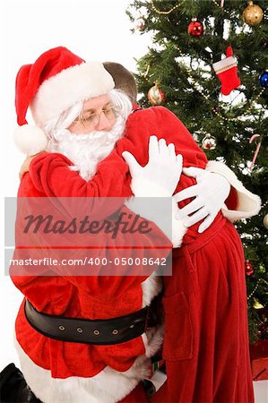 Santa Claus getting a big hug from a child on Christmas morning.  White background.