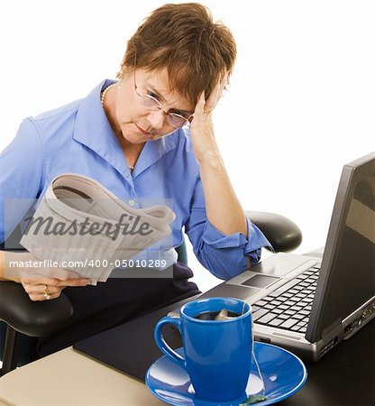 Worried woman reading the stock section of the newspaper.  White background.