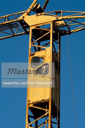 Rusty crane cabin detail over clean blue sky