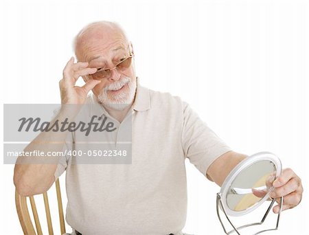 Senior man checking out his new prescription sunglasses in the mirror.
