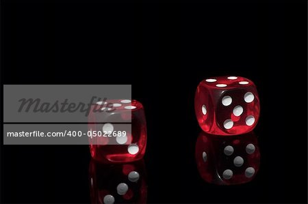 Two red casino dice on the black background