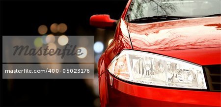 Red car in traffic at night