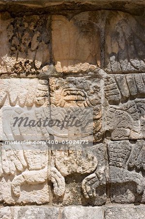 Mayan figures carved into the old stone wall at Chichen Itza. Mexico