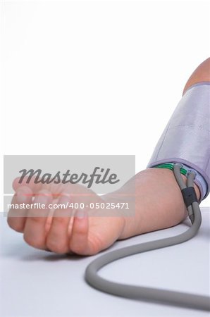 Woman measuring her blood pressure, against white background with copy space.