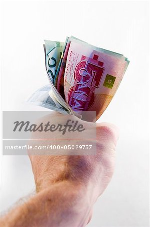 A male hand holding a tight wad of Canadian money.