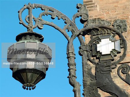 Detail of an ancient streetlamp made of bronze. It is situated in a corner of King Enzo's Palace in Bologna