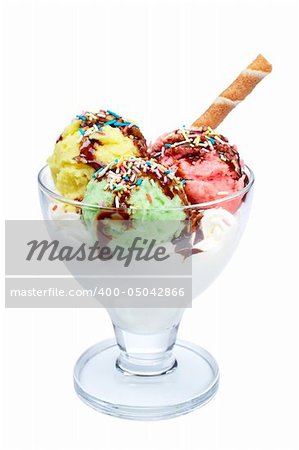 Delicious multi flavor ice cream with chocolate syrup in glass bowl isolated on white background. Shallow DOF