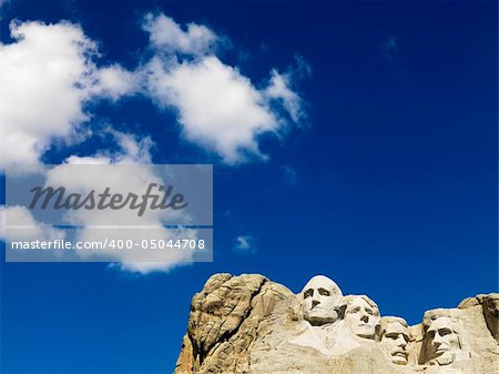 Mount Rushmore National Memorial with blue cloudy sky.