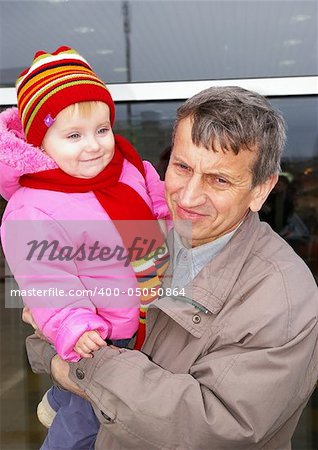 Grandfather and small grand daughter on a background of a supermarket