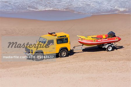 Rescue vehicle towing a rescue rubber dinghy on the beach