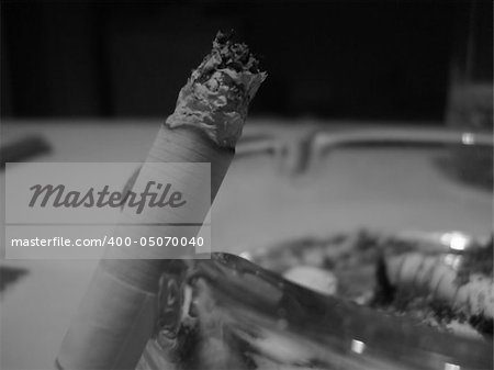 photo about white cigarette, smoke  and ash-tray