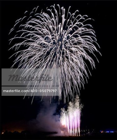 Fireworks rockets exploding against dark sky.