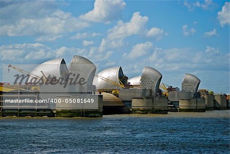 Thames Flood Defence Barrier, London, England; aircraft taking off from nearby City Airport, London, in the background