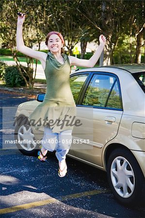 Teen girl gets new car and jumps for joy.