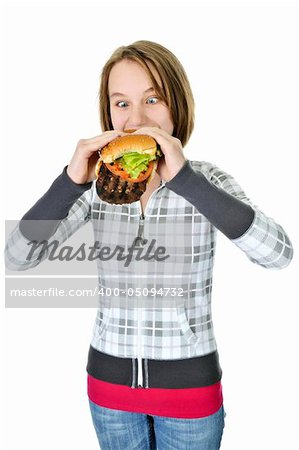 Teenage girl eating a big hamburger isolated on white background