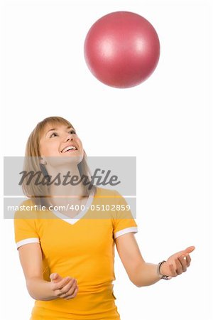 A girl throwing a red ball up