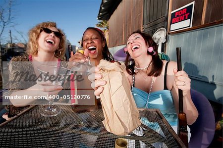 Three women outside a house drinking alcoholic beverages