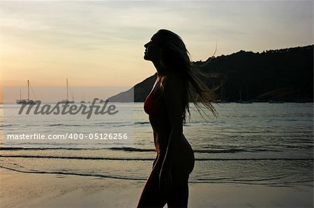 Silhouette of a beautiful young blonde girl on the beach