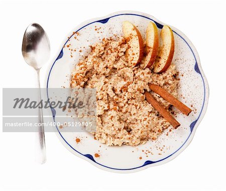 A bowl of porridge with apple and cinnamon spices isolated on white