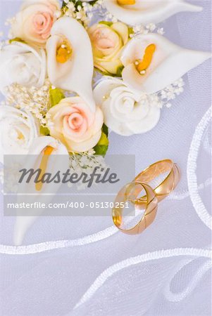 wedding rings and flowers decorations over bridal veil