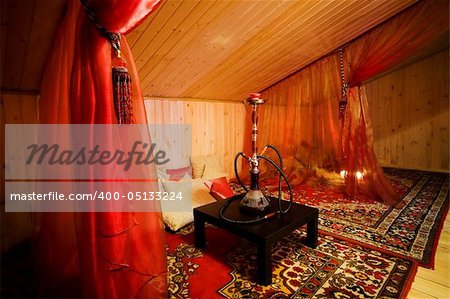 Hookah on a black table in a beautiful wooden room