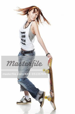 Portrait of smiling girl standing with skateboard on white background