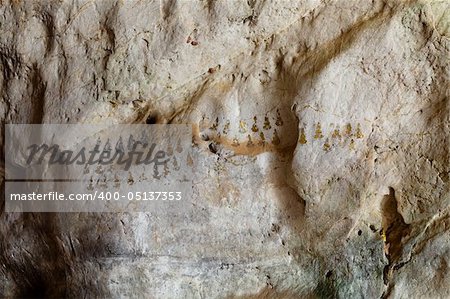 golden budhist symbols on a cave wall
