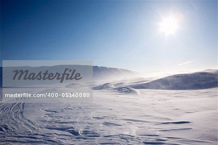 Blowing snow in a barren winter mountain landscape