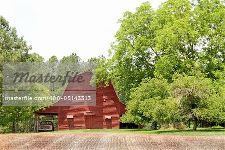 An old red barn in a rural contryside setting.