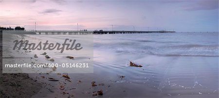 The sunset light is fading over the long pier