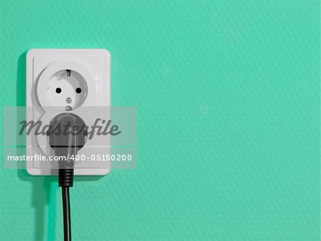 White electric socket on green wall