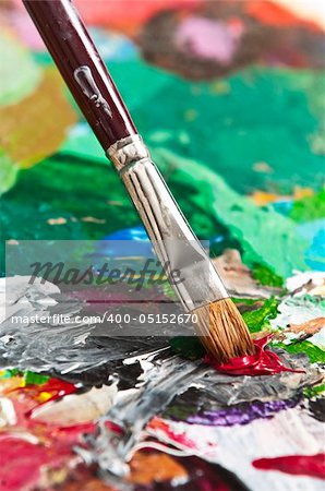 Detail of a paintbrush on an artist's palette