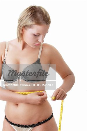 A little bit fat young woman mesuring her body isolated on white background
