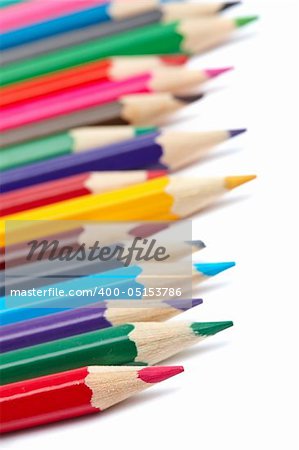 Assortment of coloured pencils with shadow on white background. Shallow depth of field