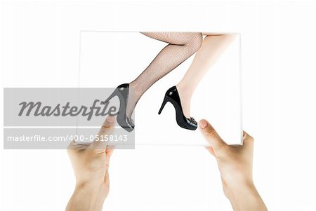 Hand holding photo of Two pretty woman legs isolated on white