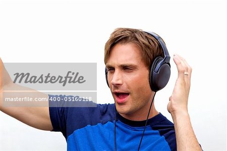 An attractive man with headphones and a blue vestA handsome man jamming out to music