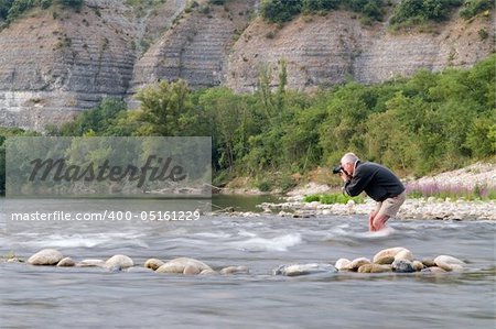 Photographer risking his camera in the stream of the Ardeche, France