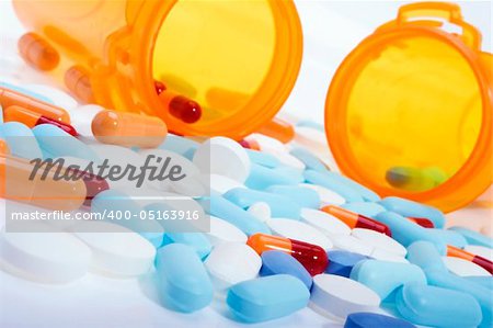 Stock image of pills, capsules and tablets of different colors over white.