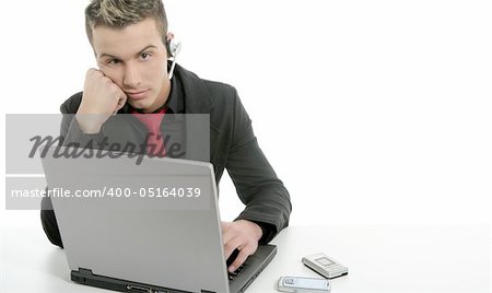 Young bored businessman with laptop and microphone