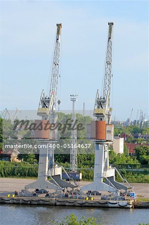 Two big cranes on the dock in a harbour
